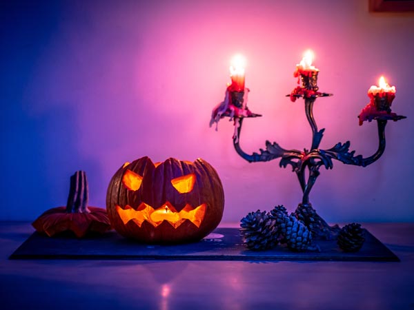 A halloween pumpkin on a table with a purple UV light background.
