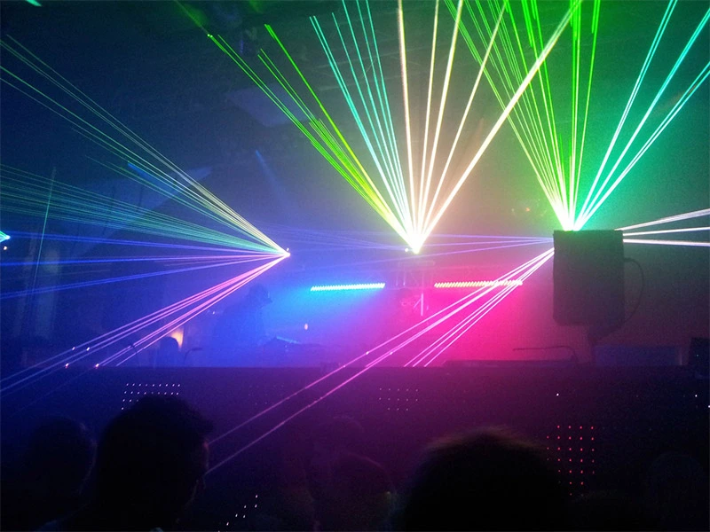 Colour DJ lasers behind a DJ booth